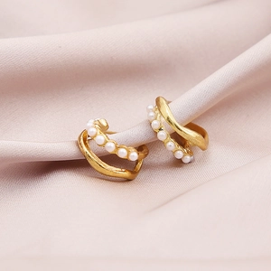 Elegant gold layered hoop earrings with embedded faux pearls on a pink satin background