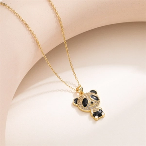 Detailed view of a golden panda necklace pendant featuring micro-pave zirconia and black enamel
