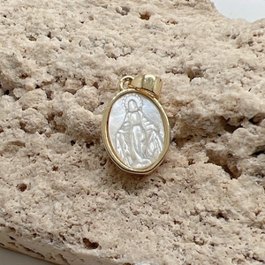 Oval gold pendant with white mother of pearl Virgin Mary relief on a stone base