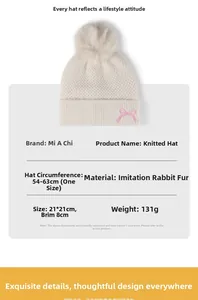 Detailansicht der beige Strickmütze mit flauschigem Bommel und rosa Schleifenstickerei