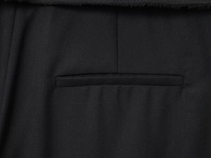 Close-up of black twill fabric stitching and pocket detail on casual trousers