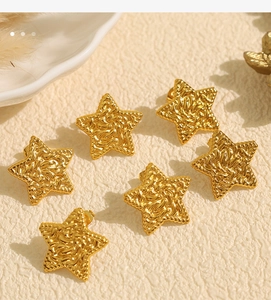 Detailed view of six gold star earrings featuring unique pleated and hammered metal textures