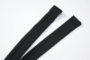 Detail of the black elastic knitted long tie-up strap with fine texture on white background