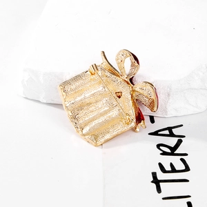 Back view of gold metal Christmas gift box brooch with red enamel and pin closure
