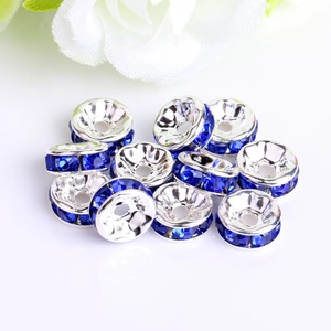 Macro detail of silver spacer beads with sparkling dark blue rhinestones for DIY jewelry