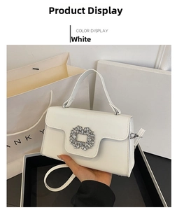 Primer plano de bolso bandolera blanco en cuero con hebilla de strass y asa de mano superior