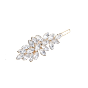 Close-up of golden metal hair clip featuring leaf-shaped crystal rhinestones on white background