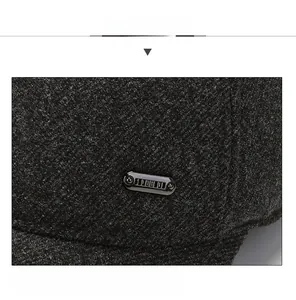 Macro detail of charcoal wool blend fabric and metallic trim on men's winter baseball cap
