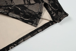 Macro shot of delicate black lace floral pattern over beige lining on a slit dress