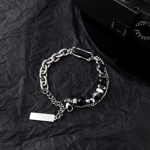 Detail of industrial punk bracelet with silver chains and black cat eye stones