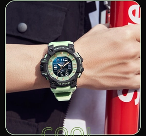 Close-up of dual-display camouflage sports watch with fluorescent green accents and buttons