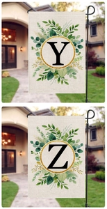 Detail of linen garden flags with letters Y and Z in gold floral wreaths on black poles