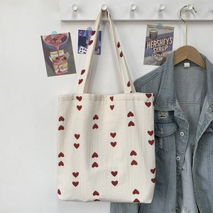 Detail view of heart-patterned waffle fabric tote bag in a cozy aesthetic setting