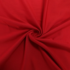 Détail macro du tissu rouge en maille douce avec des plis drapés élégants et souples