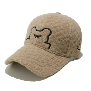 Close-up of soft camel plush baseball cap featuring a cute black bear embroidery detail