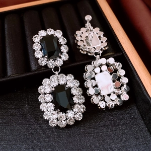 Detail of square black gemstone earrings with rhinestones and screw-on clip backings