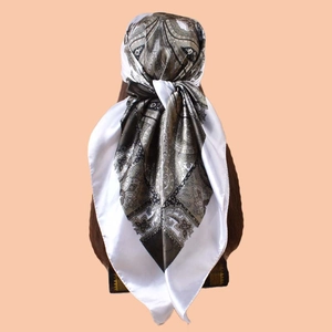 Rear view of a paisley print satin scarf tied as a headpiece in brown and beige tones