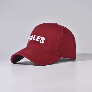Close-up of TALES 3D white embroidery on a premium burgundy cotton baseball cap fabric
