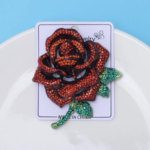 Detailed macro view of a rose brooch encrusted with red and orange rhinestones