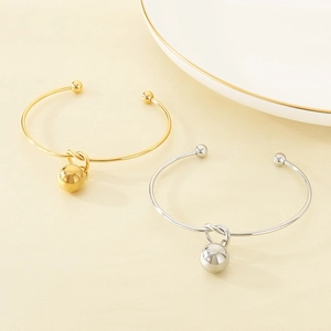 Minimalist open knot bangle with gold and silver ball pendants in polished stainless steel