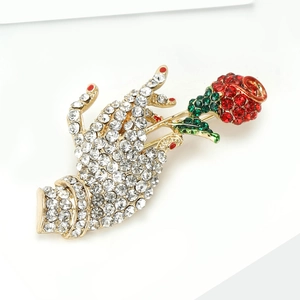 Elegant gold hand and rose brooch set with sparkling rhinestones and green enamel details