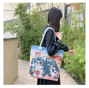 Detail of artistic woven jacquard tote bag featuring cute cat patterns and rope handles