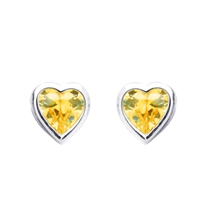 Close-up of heart-shaped earrings featuring yellow faceted gems in silver settings