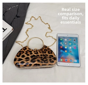Leopard print clutch bag with gold ring handle and chain shown next to a tablet