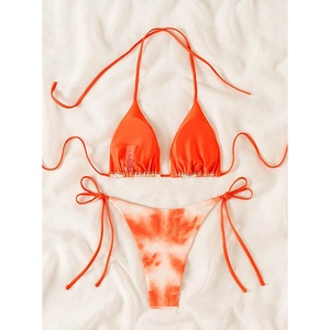 Detailed flat lay of vibrant orange bikini set with marble tie-dye print bottoms and adjustable ties