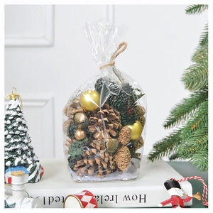 Detail of Christmas decoration pack with pine cones, golden balls and bells on white book