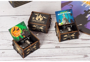 Detailed view of Halloween hand-cranked music boxes with spooky painted castle and bat designs