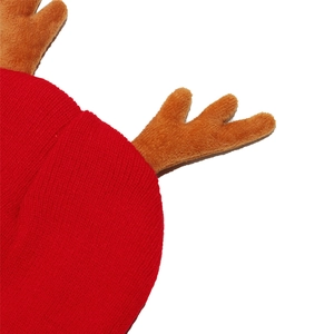 Close-up of red knit Christmas hat with soft plush brown reindeer antlers detail