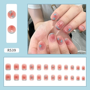 Detail van roze gradiënt plaknagels met lichtblauwe french tips en kleine sterpatronen