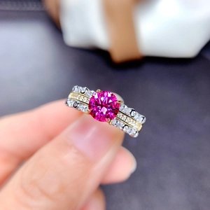 Macro shot of three-layered ring with a round pink gemstone and silver-gold pavé bands