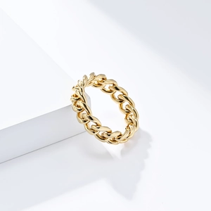 Detailed view of golden Cuban link chain ring on white geometric display stand