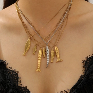 Elegant gold and silver fish pendant necklaces displayed on a model in black lace top