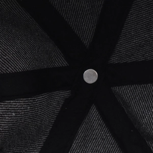 Detail of internal reinforced stitching and metal rivet on washed denim baseball cap