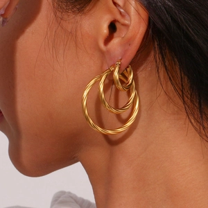 Detailed view of three gold twisted rope earrings in small medium and large sizes