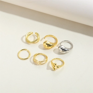 Macro shot of a six-piece luxury gold and silver ring set featuring water drop and pave designs
