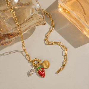 Dettaglio della collana placcata oro 18K con ciondoli fragola rossa, conchiglia e chiocciola