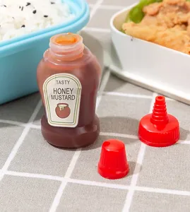 Macro shot of a mini squeeze bottle for honey mustard in a bento lunch box setting