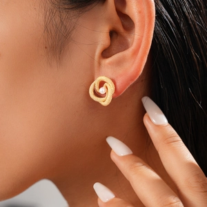 Close-up of vintage twisted gold earrings with pearls worn by a model in soft lighting