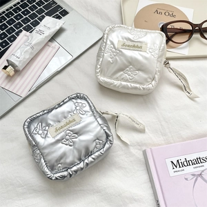 Flat lay of quilted heart pouches in silver and cream with stylish bow textures