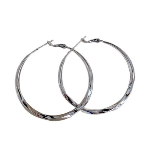 Minimalist silver twist hoop earrings with textured metal design on white background