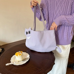 Detailed embroidery of cartoon cat face on a light purple canvas tote bag with soft texture