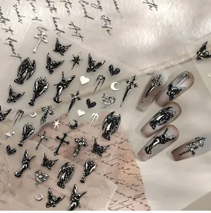 Detail of gothic 3D embossed nail stickers featuring silver angel and cross designs
