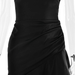 Detailed view of the side pleats and ruched fabric texture on this black evening dress