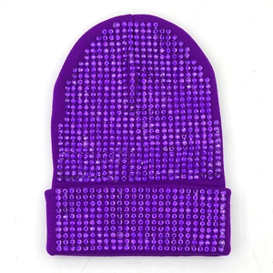 Dettaglio del berretto in maglia viola scuro con strass scintillanti e risvolto ampio