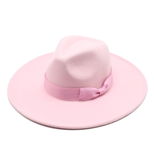 Detail of light pink wool fedora hat featuring wide brim and elegant satin bow ribbon