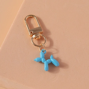 Detail view of a sky blue balloon dog keychain with a polished resin surface and gold clasp